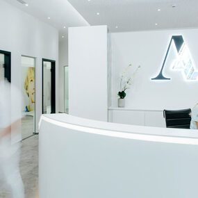 Heller Empfangsbereich einer modernen Zahnarztpraxis mit freundlicher Atmosphäre.